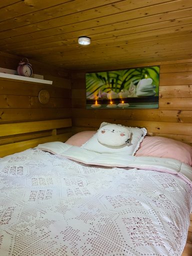 Sfeervolle slaapkamer met houten wanden en een knuffel op bed.